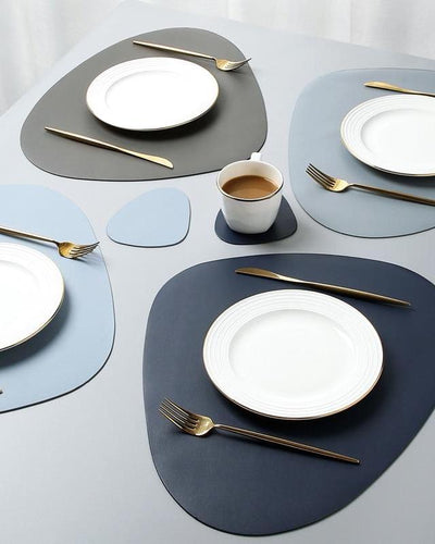 golden tableware on colorful placemats in oval shape
