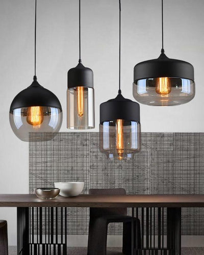 Three ceiling lamps hanging in a dining room on top of a wooden table next to a kitchen