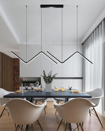 A wave ceiling lamp in black hanging in a living room over a dining table with two chairs
