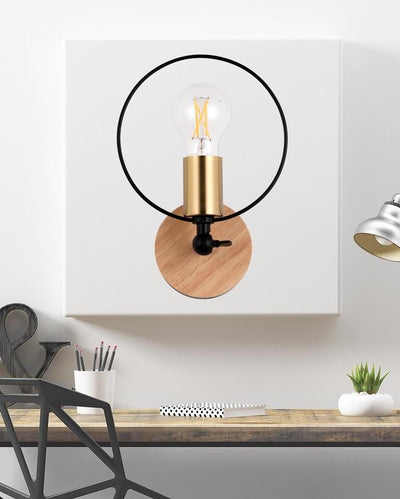 A cicular wall lamp with a wooden base and a black ring hanging on a white wall