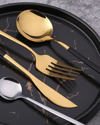 golden cutlery on a black plate