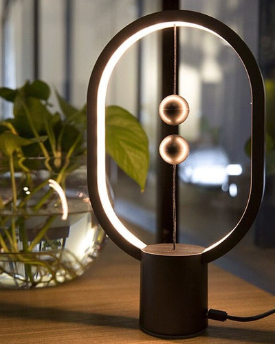 Magnetic eclipse lamp in black on a wooden table