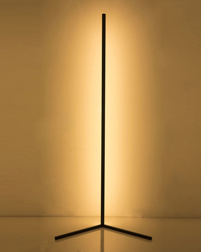 Geometric tripod floor lamp in black color with a long rod emitting warm light